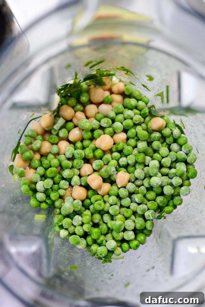 Vibrant Green Goddess Hummus 8 Adding rinsed chickpeas and green peas to the blender