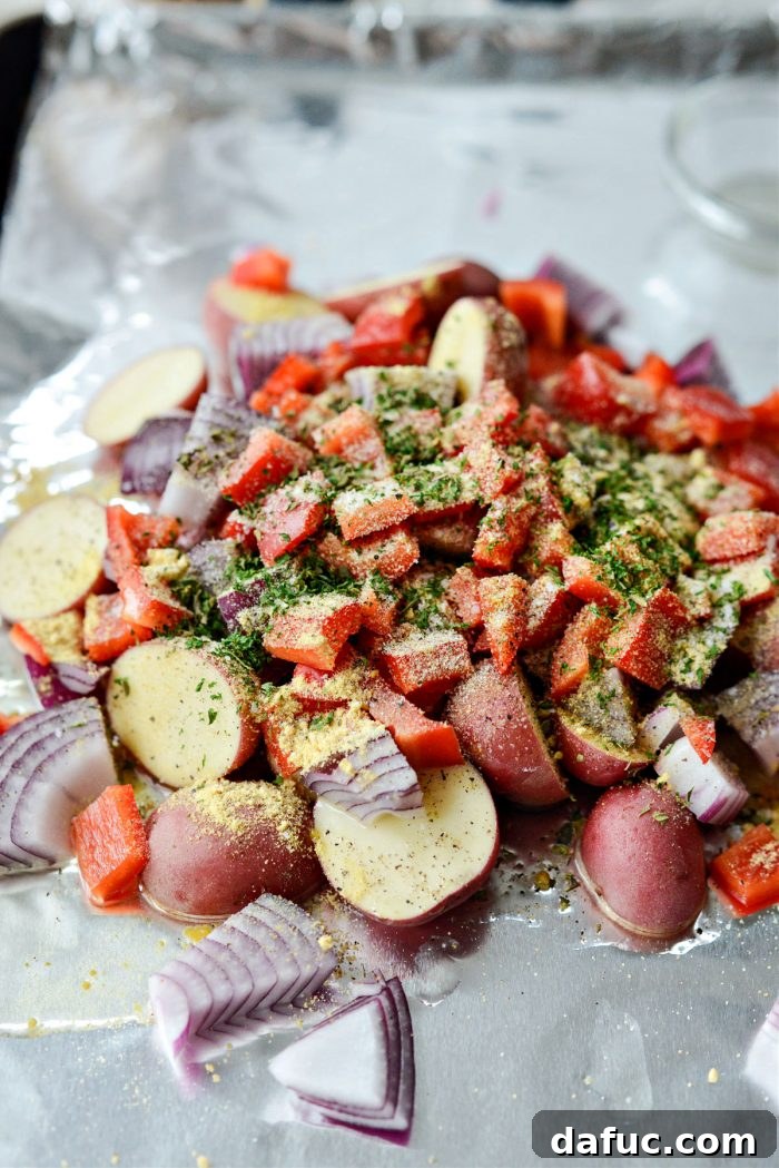 Drizzle oil and add dried herbs and spices to vegetables on sheet pan