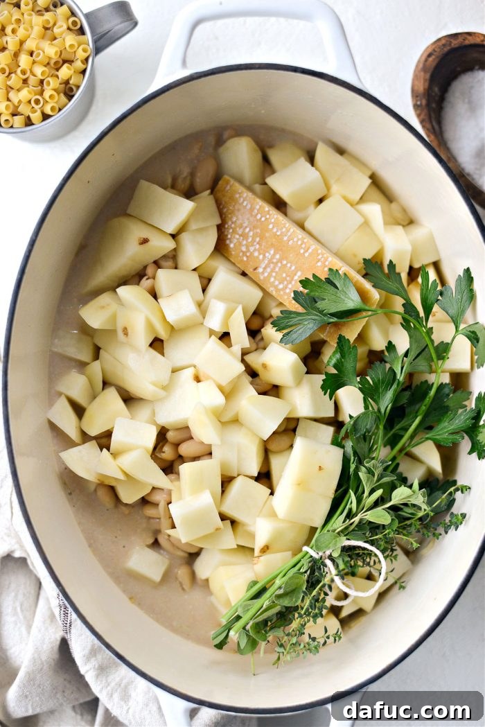 Silken Pasta e Fagioli 14 add bean puree, beans, potatoes, parmesan rind, and herb bundle to pot