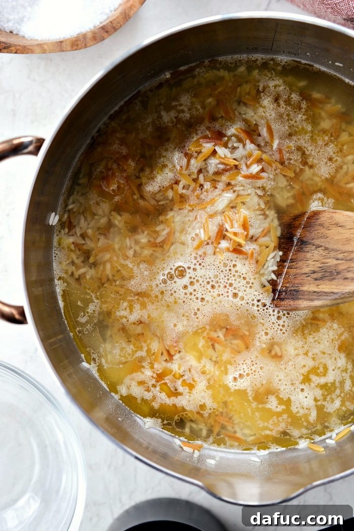 Pouring chicken broth and water into the saucepan with rice and orzo for pilaf