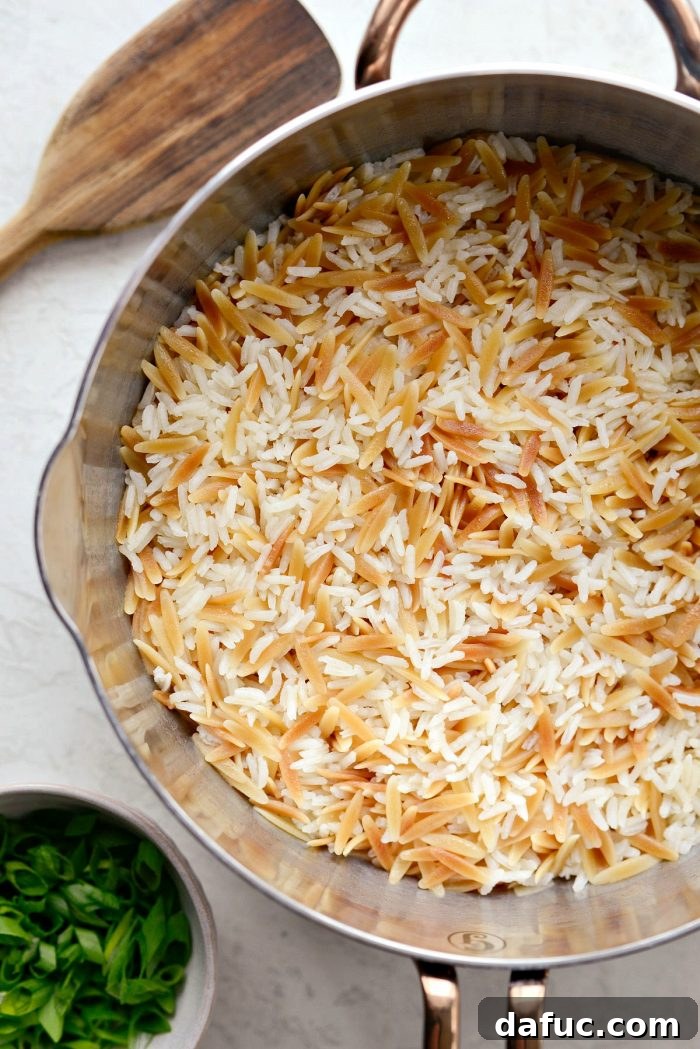 Covered saucepan of cooked rice pilaf resting off the heat