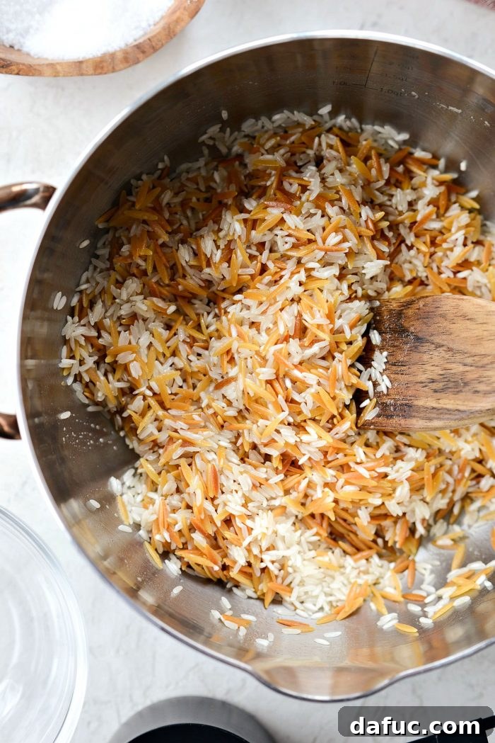 Adding long-grain rice to the toasted orzo in the saucepan for rice pilaf