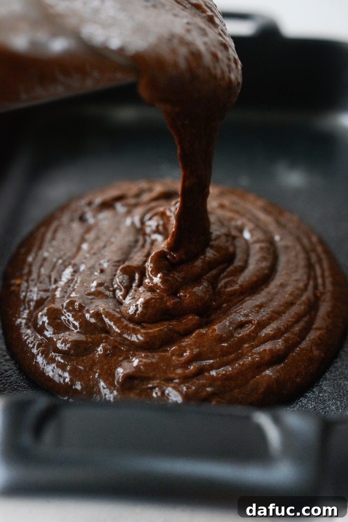 Decadent Chocolate Garden Delight 16 Pouring finished cake batter into a prepared 9x13 inch baking pan