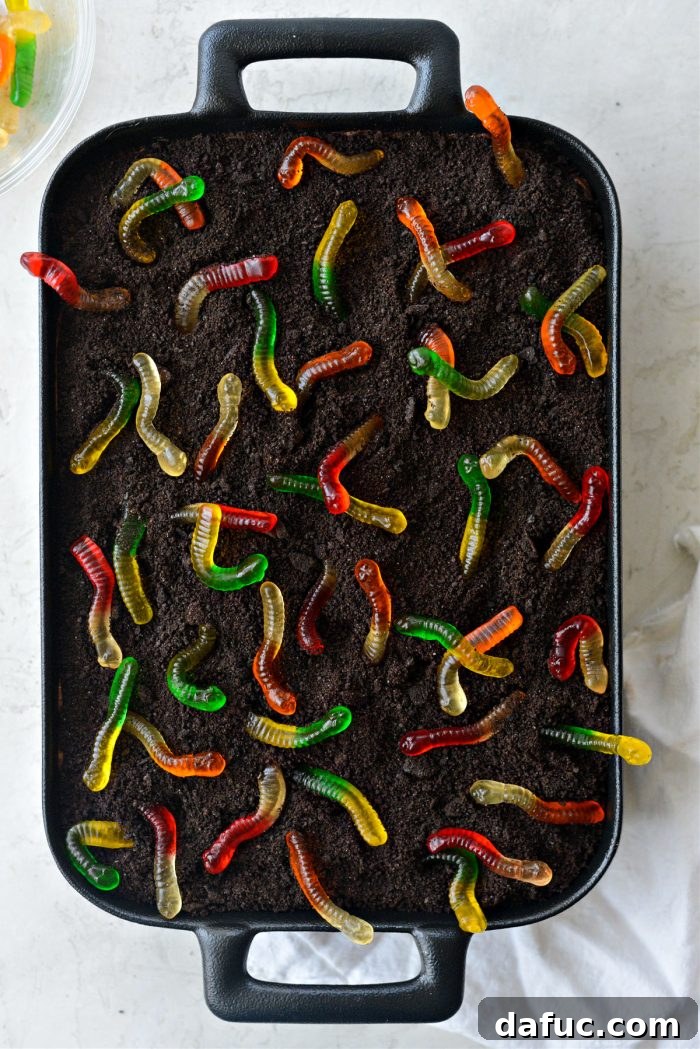 Decadent Chocolate Garden Delight 26 Arranging colorful gummy worms playfully on the Chocolate Dirt Cake