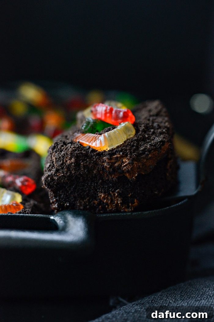 Decadent Chocolate Garden Delight 28 A person serving a slice of Chocolate Dirt Cake with a spatula