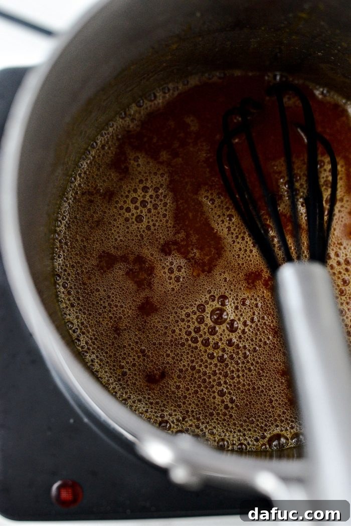 Whisking butter into caramel until fully melted