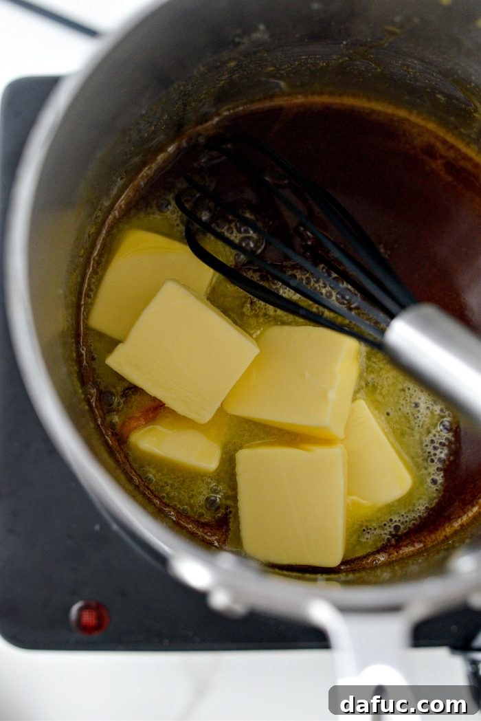 Adding room temperature salted butter to the hot caramel