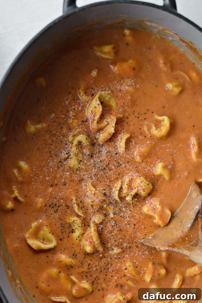 Seasoning the soup with salt and pepper.