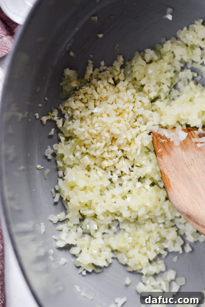 Minced garlic being added to sautéed onions.