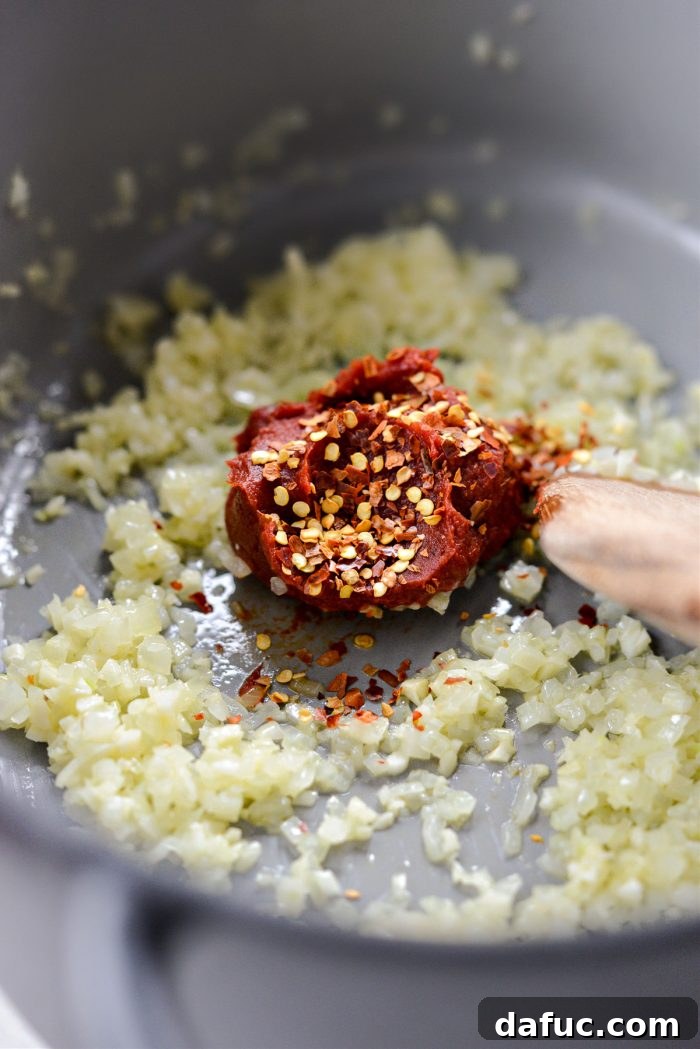 Tomato paste and red pepper flakes added to the sautéed mixture.
