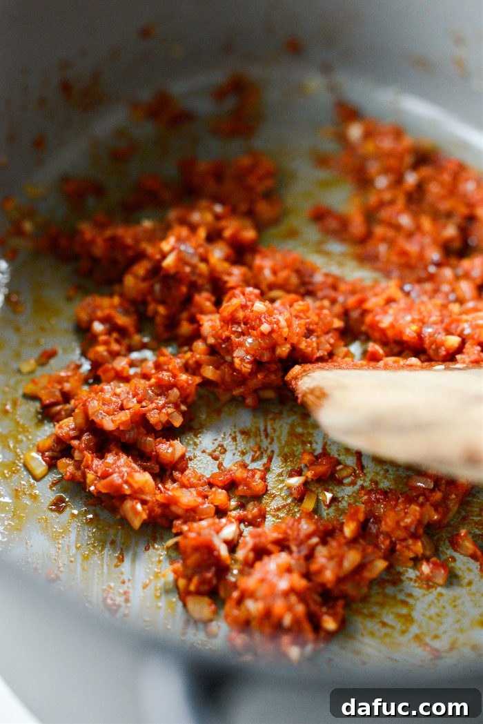 The tomato paste and chili flakes cooking in the pot.