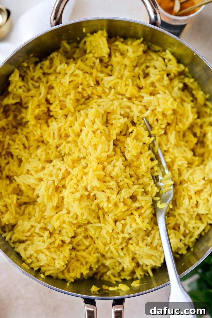 Golden Turmeric Rice 17 Fluffing Turmeric Rice with a fork