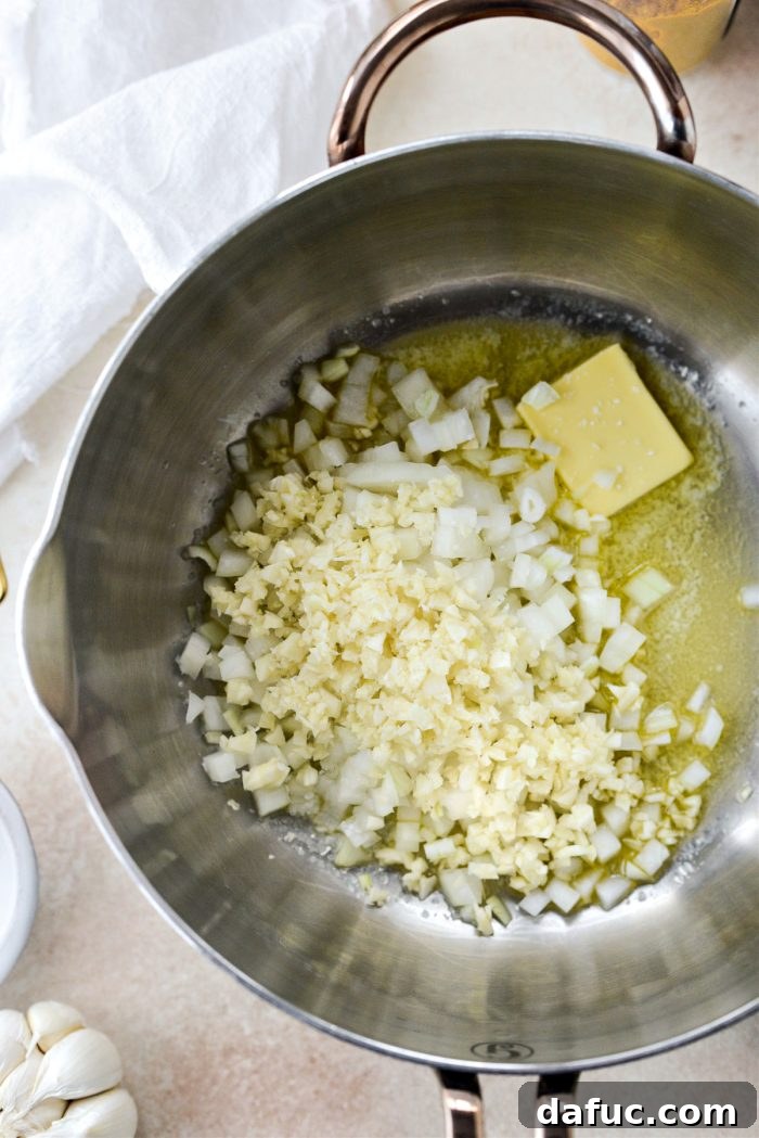 Golden Turmeric Rice 5 Melting butter and adding diced onions and minced garlic to a pot