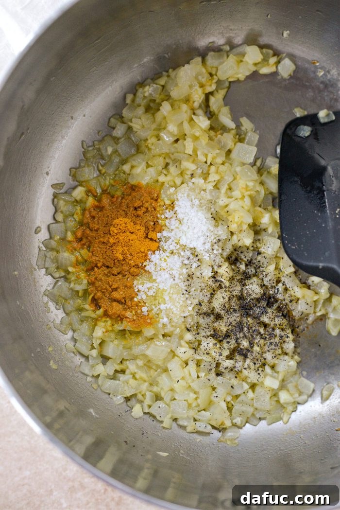 Golden Turmeric Rice 8 Adding turmeric, kosher salt, and black pepper to sautéed onions and garlic