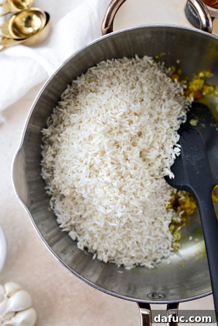 Golden Turmeric Rice 10 Adding rinsed basmati rice to the pot with aromatics and spices