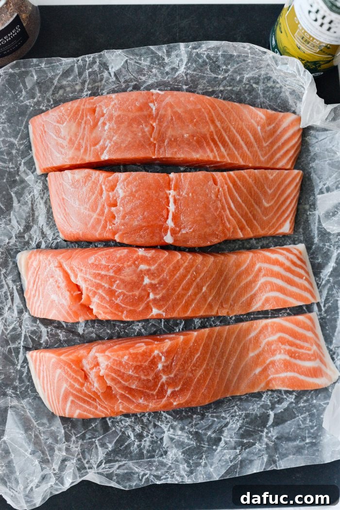 Crispy Air-Fried Blackened Salmon 7 Misting a salmon fillet with ghee oil spray on a cutting board
