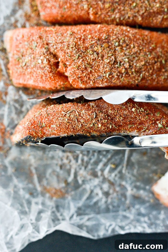 Showing a salmon fillet fully coated with blackened seasoning on all sides