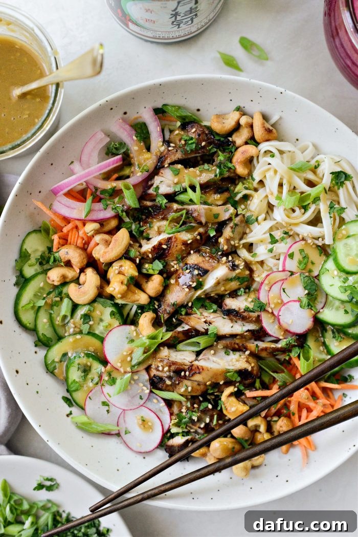 Savory Sesame Grilled Chicken Noodle Bowls 2 Grilled Sesame Chicken Noodle Bowls - A healthy and flavorful meal featuring marinated chicken, fresh vegetables, and rice noodles with sesame dressing.