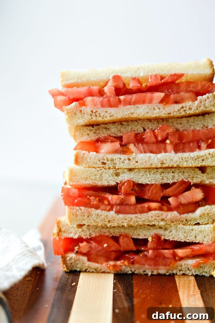 A beautifully presented Classic Tomato Sandwich on a plate, ready to be enjoyed.