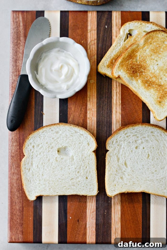 Two slices of bread, one lightly toasted and the other untoasted, illustrating the choice for a tomato sandwich.