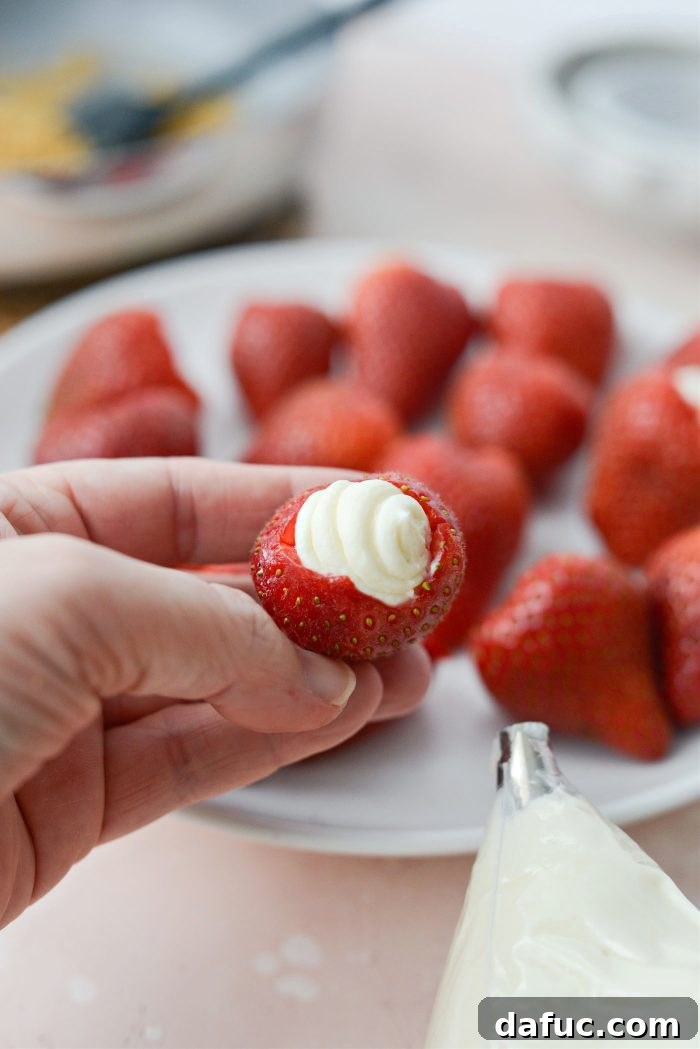 Creamy Strawberry Cheesecake Bites 11 Strawberry being filled with creamy cheesecake mixture