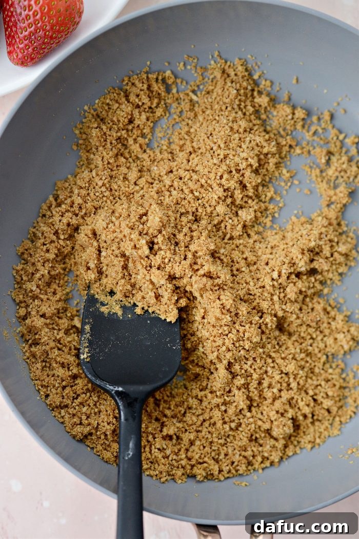Creamy Strawberry Cheesecake Bites 7 Graham cracker crumbs being stirred into browned butter