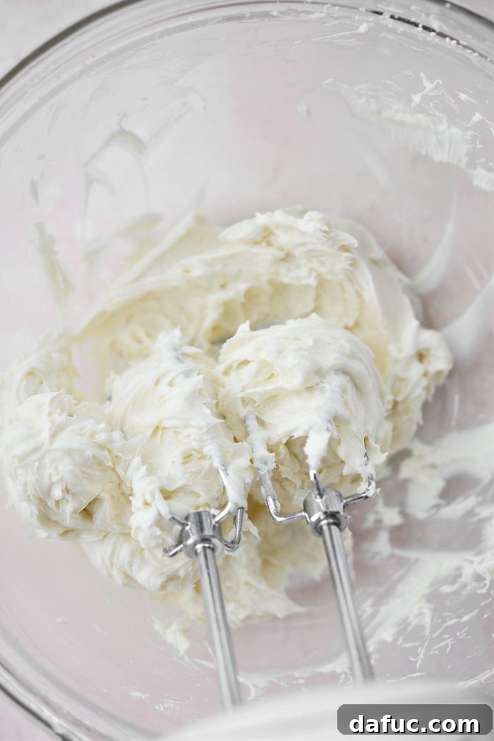 Creamy Strawberry Cheesecake Bites 9 Cheesecake filling being blended with a hand mixer until smooth