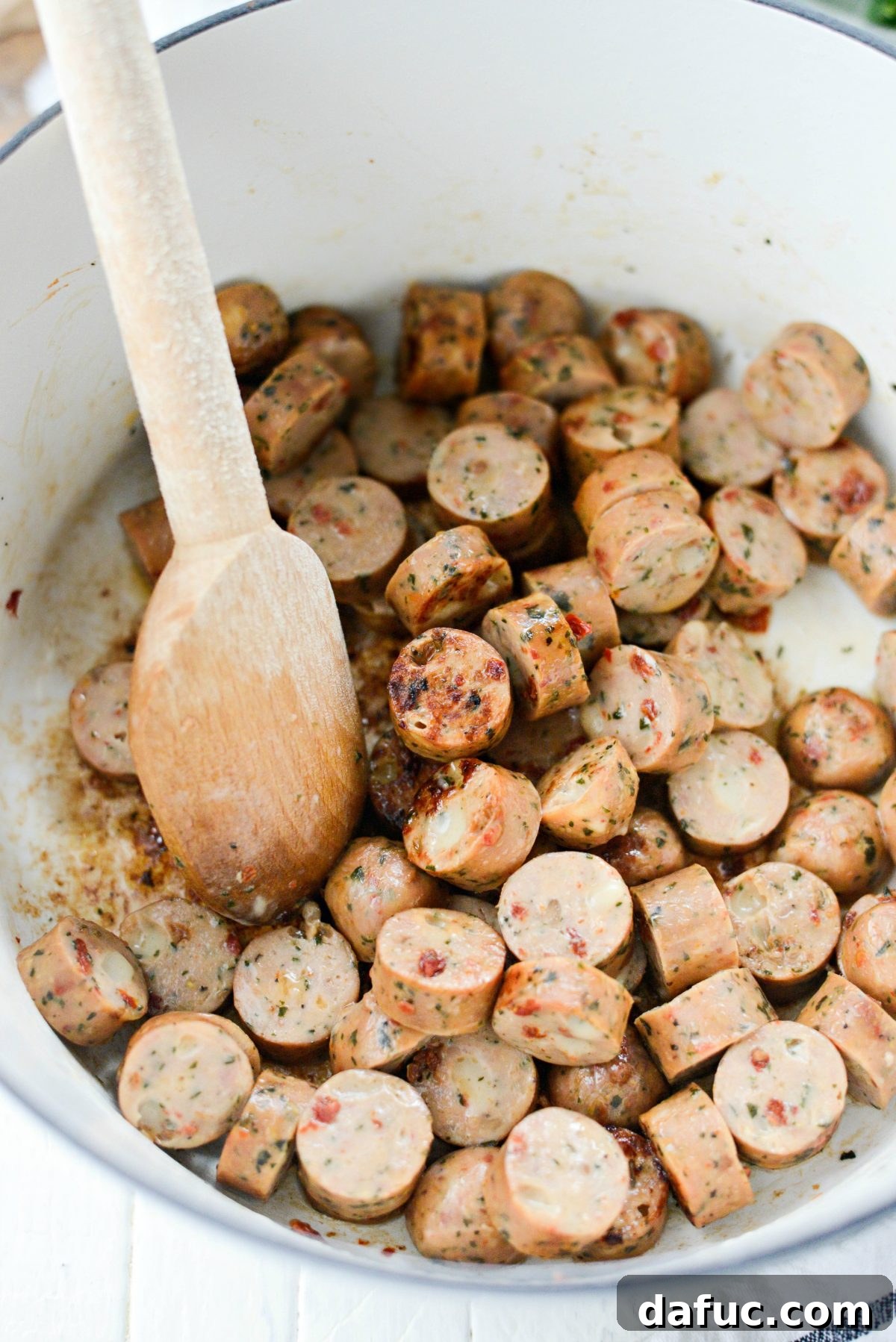 Rustic Chicken Sausage and White Bean Pot 5 Sliced chicken sausages browning in a Dutch oven with olive oil