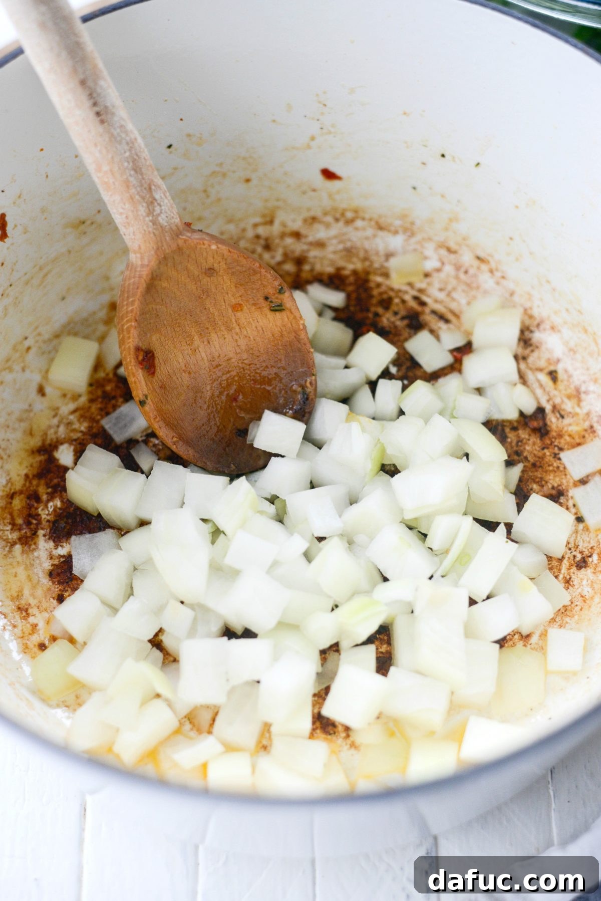 Rustic Chicken Sausage and White Bean Pot 6 Diced onions sautéing in olive oil in a Dutch oven