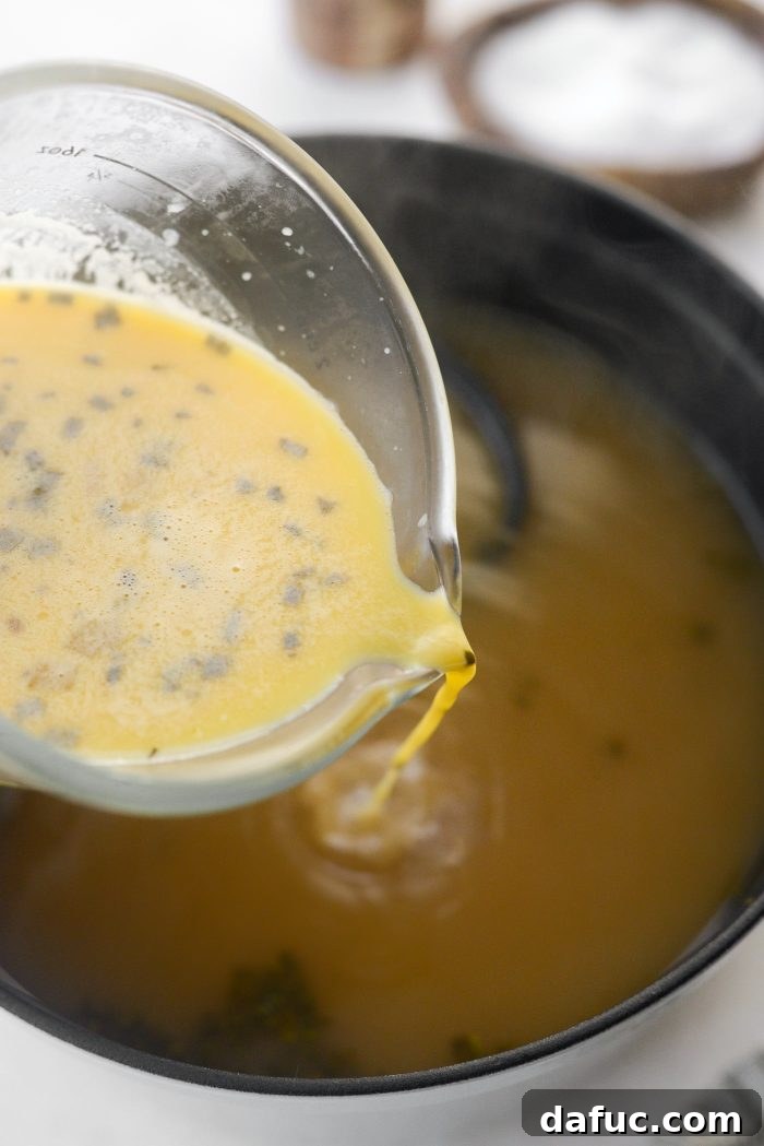 Pouring tempered eggs back into the soup.
