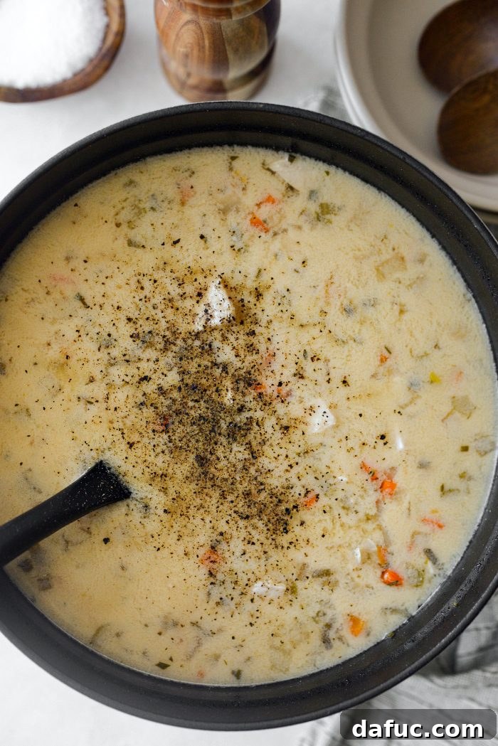 Seasoning the soup with salt and pepper.