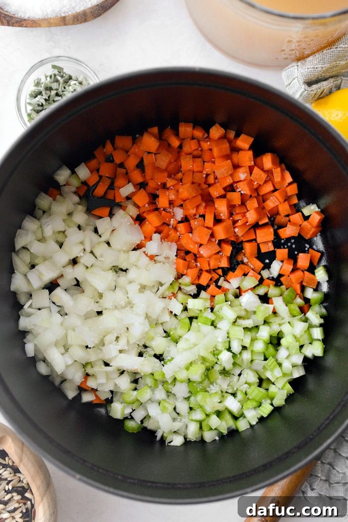 Adding carrots, celery, and onion to the hot oil with a pinch of salt.