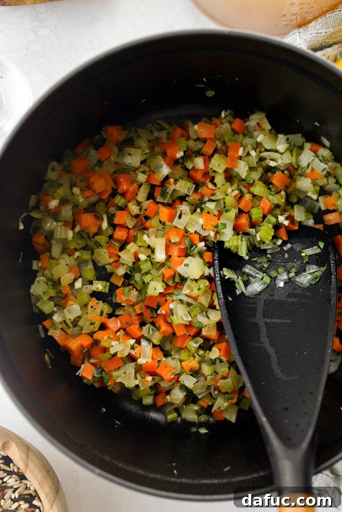 Stirring garlic and herbs into the soup base.