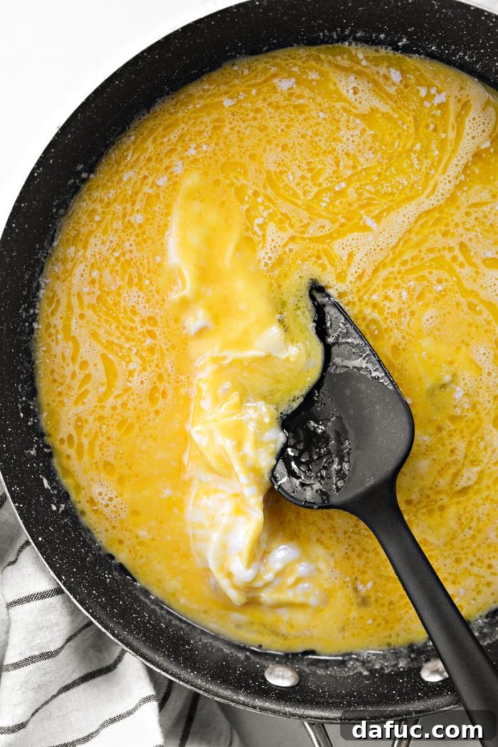 Cooking scrambled eggs, gently scraping from the bottom