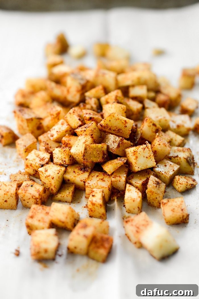 Tossing diced potatoes with oil and spices by hand