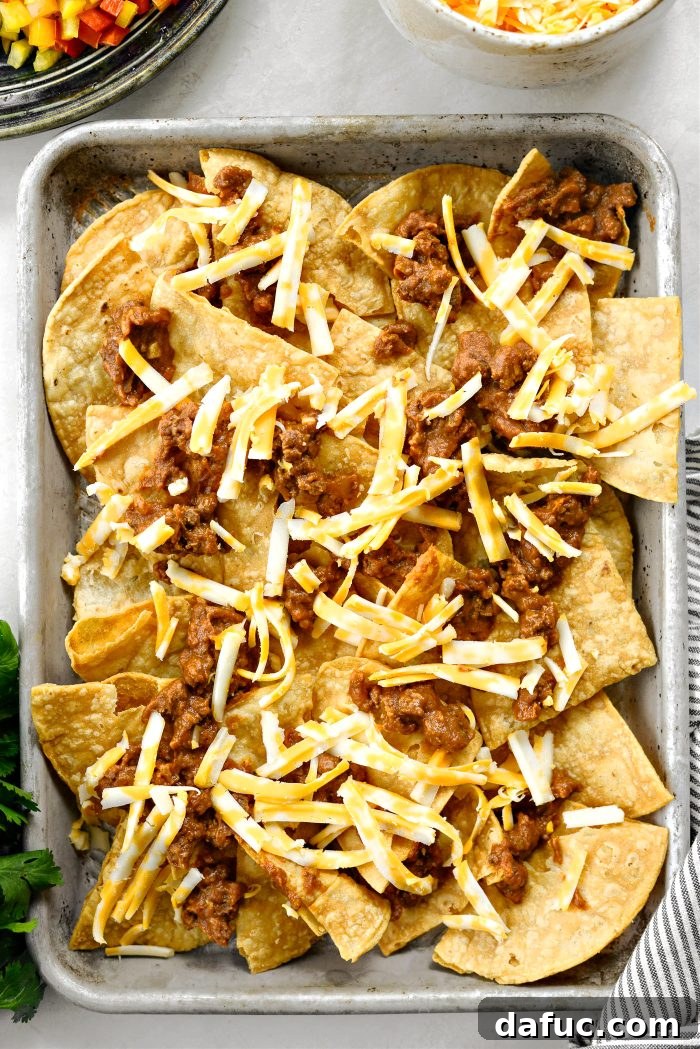 Ultimate Beef and Bean Nachos 13 top with beef and bean mixture and a little cheese