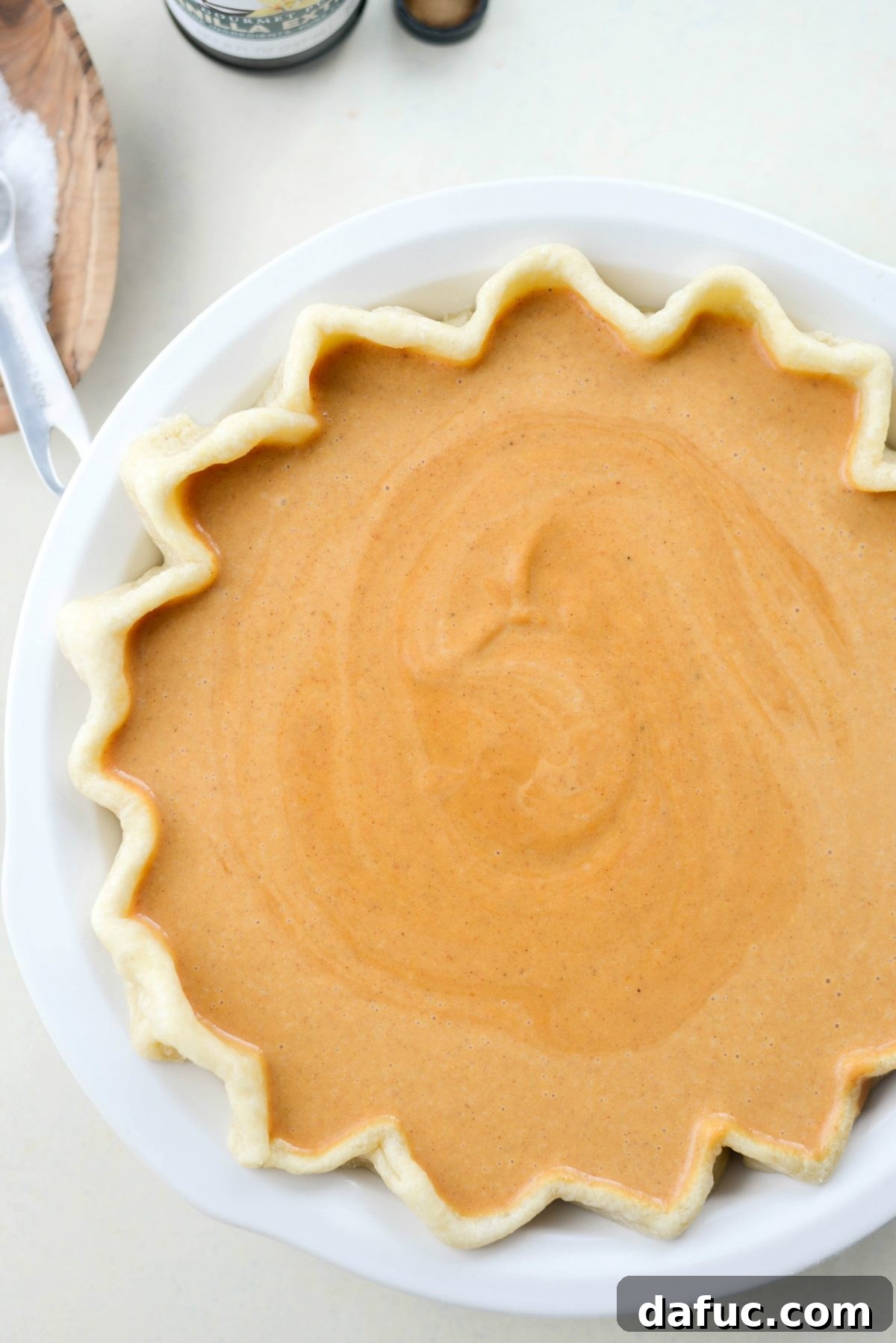 Sliding pumpkin pie into a preheated oven for baking
