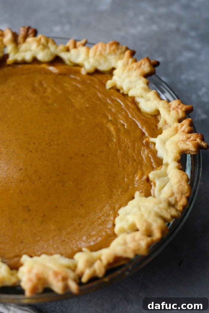 Close-up of a slice of Classic Pumpkin Pie with a creamy texture