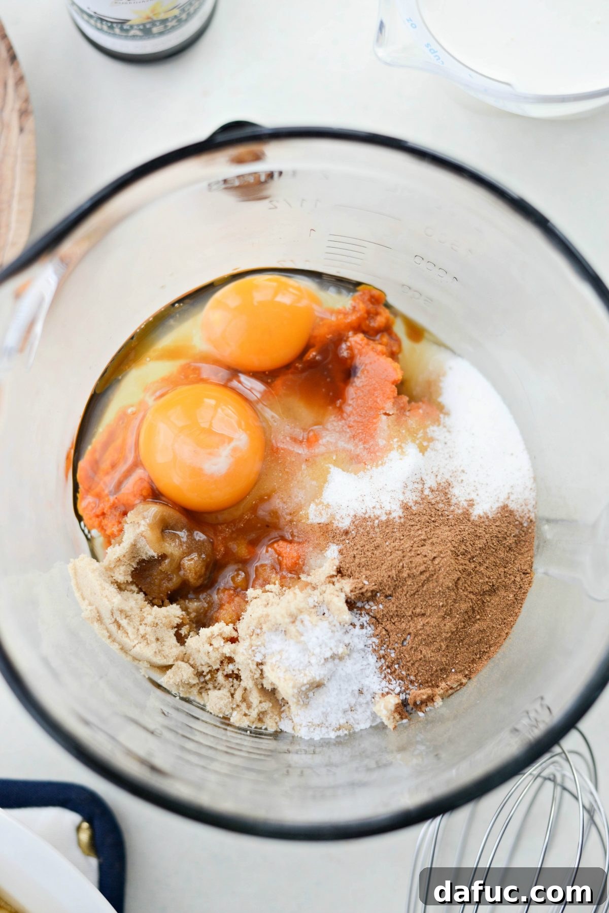 Measured pumpkin puree and spices in a mixing bowl for pie filling