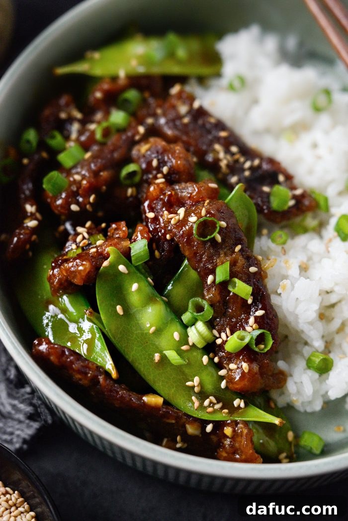 Spicy-Sweet Crispy Beef and Snap Peas 24 A final, artfully presented shot of the Crispy Honey Sriracha Beef and Snow Peas, garnished with fresh green onions and toasted sesame seeds.
