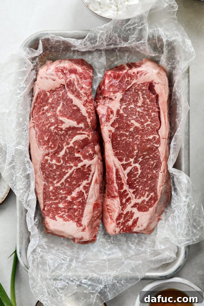 Spicy-Sweet Crispy Beef and Snap Peas 6 An uncut strip steak resting on a cutting board, poised for precise slicing.