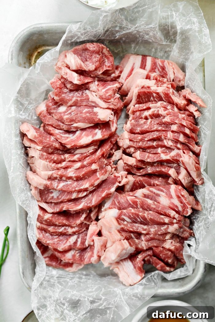 Spicy-Sweet Crispy Beef and Snap Peas 7 Expertly thinly sliced strip steak strips arranged neatly on a pristine cutting board.