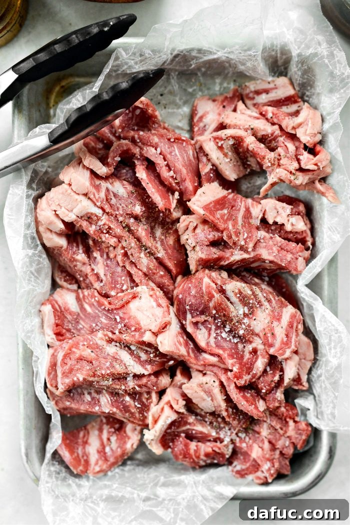Spicy-Sweet Crispy Beef and Snap Peas 9 Hands expertly tossing seasoned steak strips in a bowl to ensure every piece is thoroughly coated.