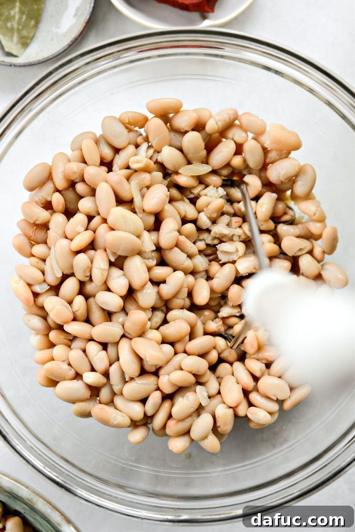 add 2 cans beans to a bowl and smash