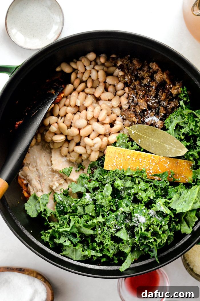 add smashed beans, whole beans, kale, Italian sausage, parm rind and bay leaf with salt to the pot