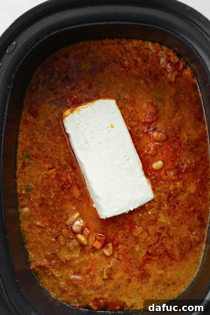 Adding softened cream cheese to the slow cooker