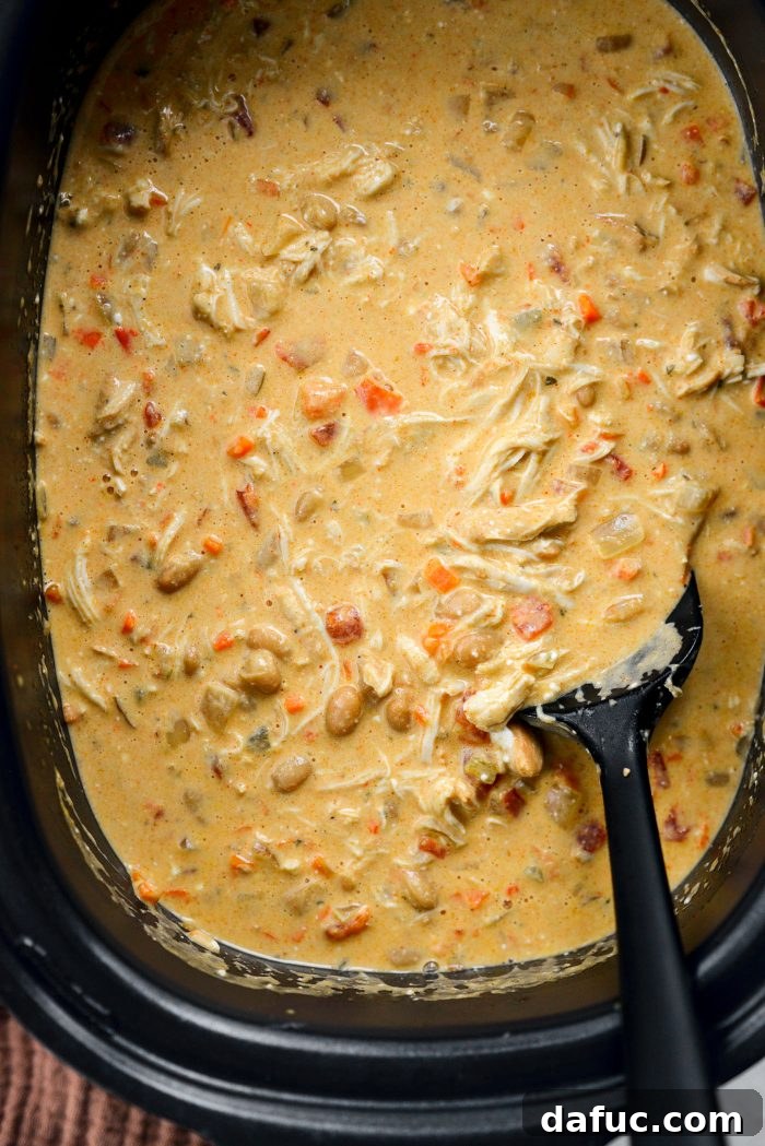 Stirring shredded chicken into the creamy buffalo chicken chili