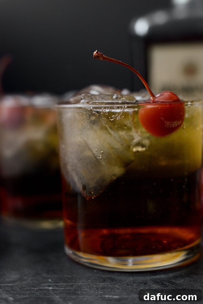 Spiced Amaretto Elixir 12 Amaretto Ginger Cocktail close up, showing texture and vibrant cherry
