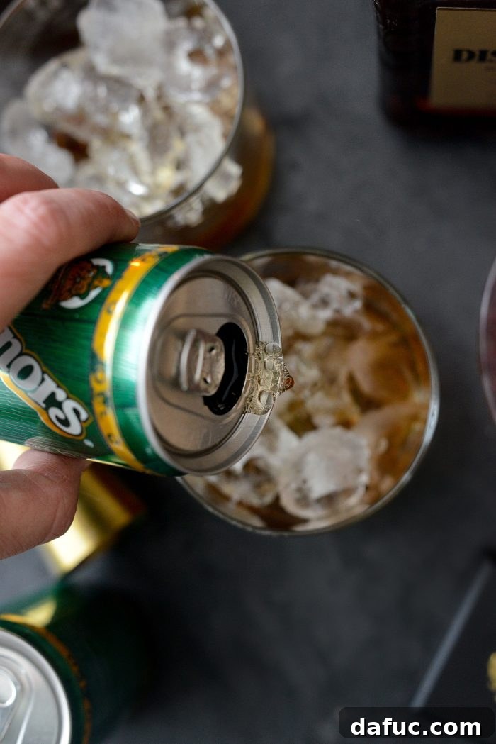 Spiced Amaretto Elixir 7 Adding ginger ale to the glass with amaretto and ice