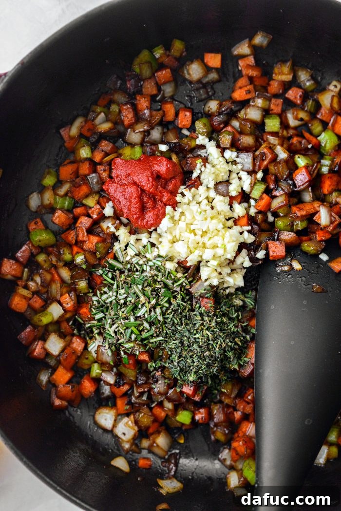to sautéed veggies add tomato paste, garlic, rosemary and thyme